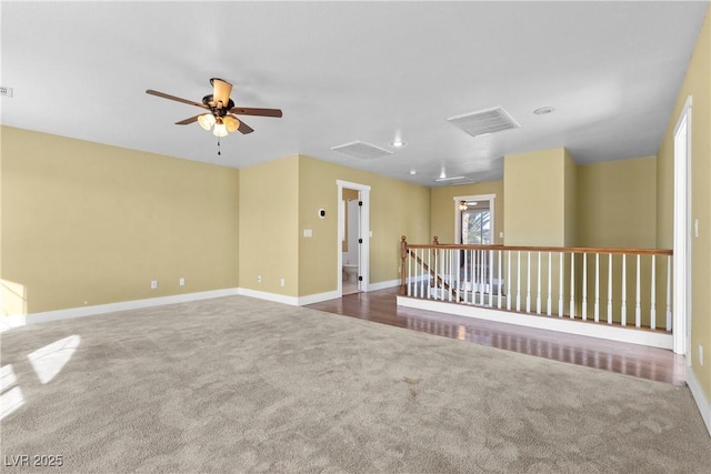 spare room featuring visible vents, baseboards, ceiling fan, and carpet flooring