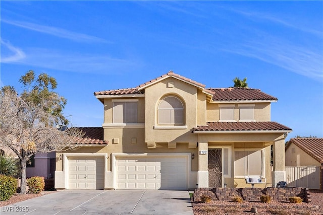 mediterranean / spanish-style house featuring fence, an attached garage, stucco siding, concrete driveway, and a tiled roof