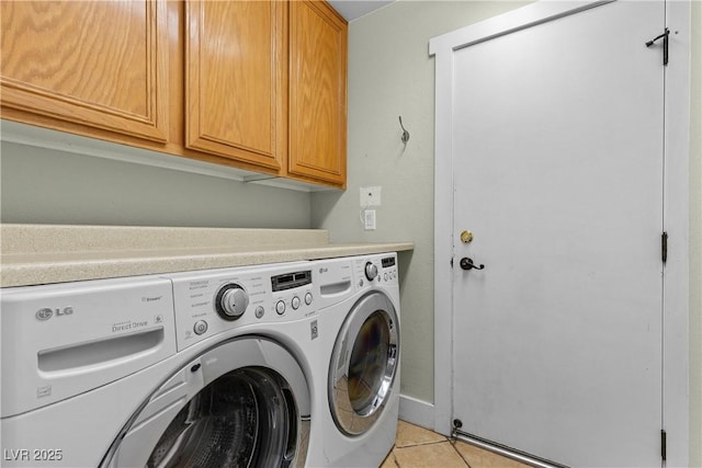 washroom with cabinet space, washing machine and dryer, and light tile patterned flooring