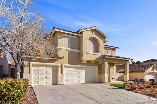 mediterranean / spanish-style home featuring concrete driveway, a tiled roof, an attached garage, and stucco siding