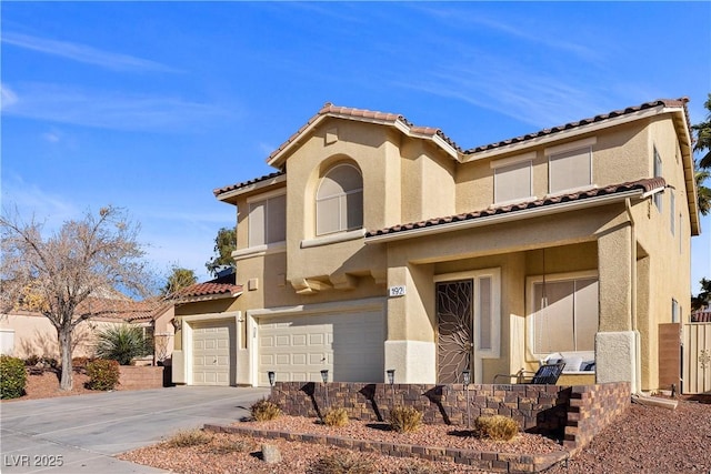 mediterranean / spanish-style home with stucco siding, driveway, a tile roof, and a garage