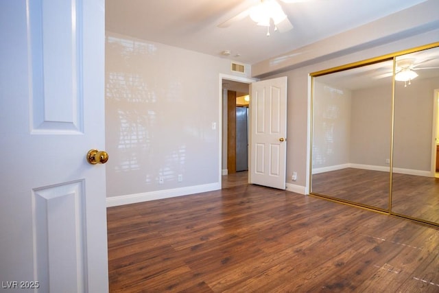 unfurnished bedroom featuring visible vents, baseboards, wood finished floors, a closet, and a ceiling fan