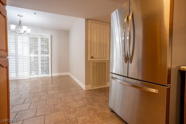 kitchen featuring visible vents, baseboards, a chandelier, light tile patterned floors, and freestanding refrigerator