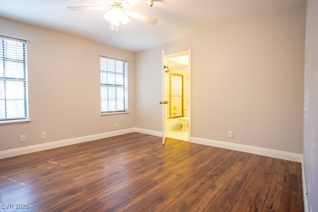 spare room featuring dark wood-style floors, baseboards, and a ceiling fan