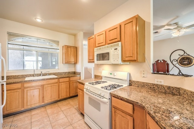 kitchen with ceiling fan, light stone counters, light tile patterned flooring, white appliances, and a sink