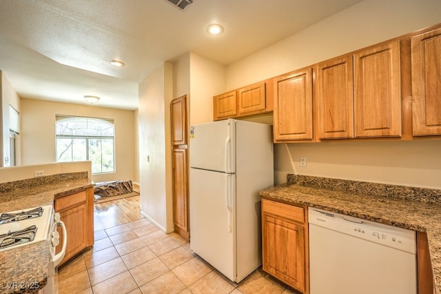 kitchen featuring white appliances, light tile patterned floors, dark countertops, and recessed lighting