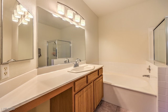 full bath with tile patterned floors, vanity, a garden tub, and a shower stall