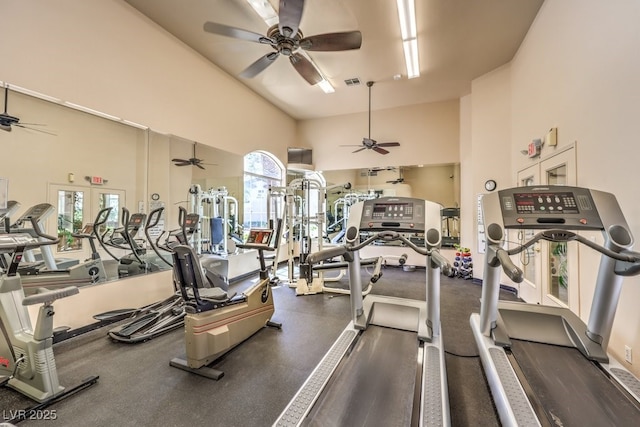 gym with plenty of natural light, ceiling fan, and a towering ceiling