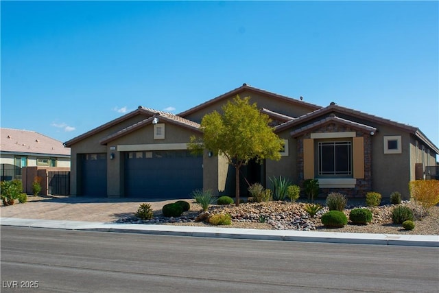 view of front facade featuring stucco siding, driveway, a tile roof, and a garage