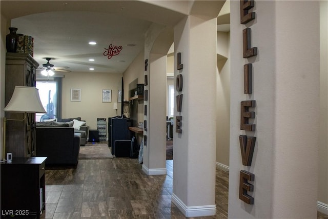 hallway with recessed lighting, baseboards, arched walkways, and dark wood-style flooring