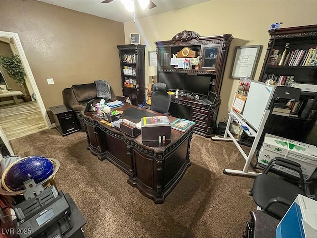 carpeted home office featuring ceiling fan