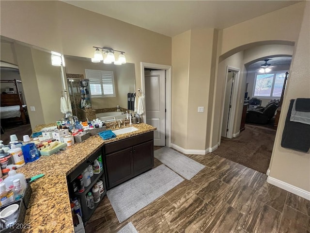 ensuite bathroom with a shower stall, baseboards, ensuite bathroom, and a garden tub