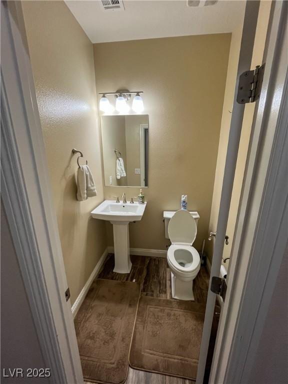 bathroom featuring visible vents, toilet, and baseboards