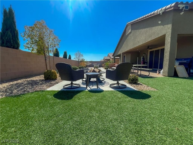 view of yard featuring a patio, a fenced backyard, and a fire pit