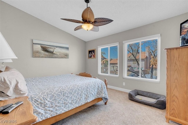 carpeted bedroom featuring baseboards, lofted ceiling, and ceiling fan