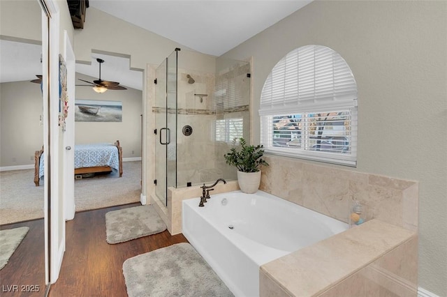 bathroom featuring a garden tub, a stall shower, ensuite bathroom, wood finished floors, and vaulted ceiling