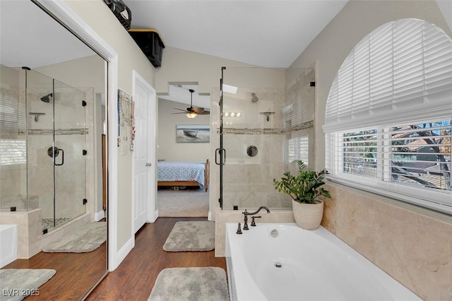 ensuite bathroom featuring a garden tub, wood finished floors, a ceiling fan, and vaulted ceiling