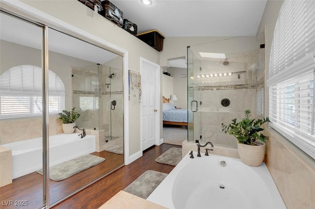 ensuite bathroom with a bathing tub, plenty of natural light, ensuite bath, and wood finished floors