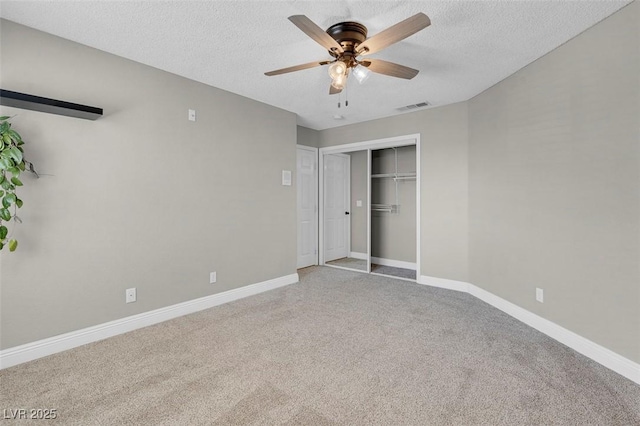 unfurnished bedroom featuring visible vents, a textured ceiling, a closet, carpet, and baseboards