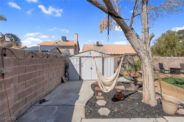 view of yard with an outbuilding, a storage shed, and a fenced backyard