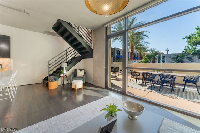 interior space with floor to ceiling windows, stairs, and wood finished floors