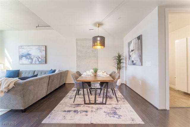 dining space with dark wood-style floors, visible vents, and baseboards