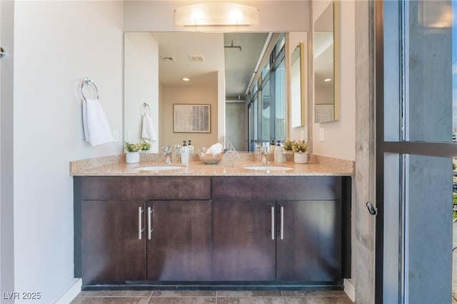 bathroom with double vanity, visible vents, and a sink