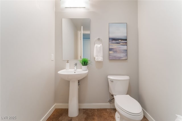 bathroom featuring tile patterned flooring, toilet, and baseboards