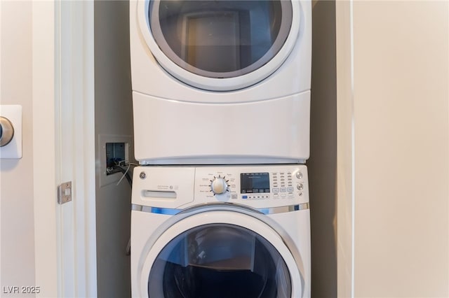 laundry area featuring stacked washer / drying machine and laundry area