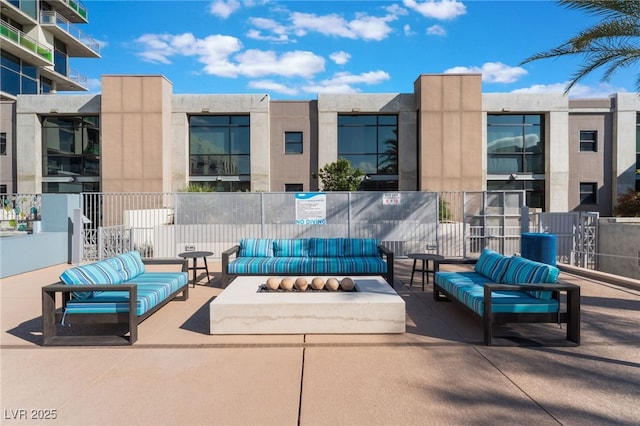 view of patio / terrace with an outdoor living space with a fire pit and fence