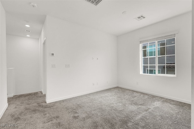 carpeted empty room featuring baseboards, visible vents, and recessed lighting