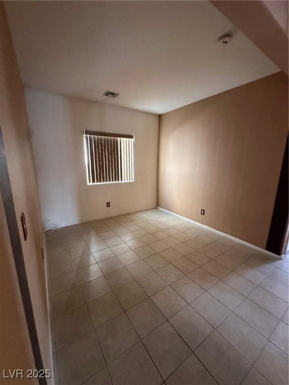 spare room featuring tile patterned floors and visible vents