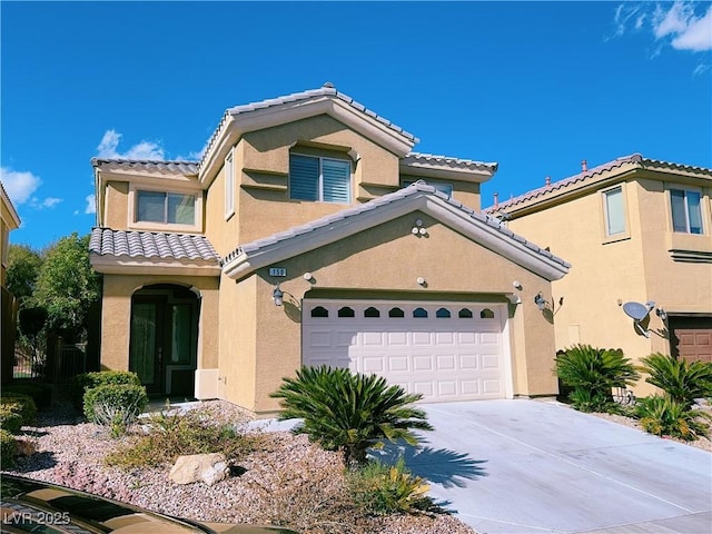 mediterranean / spanish-style home featuring concrete driveway, a garage, a tile roof, and stucco siding