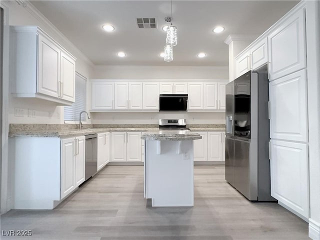 kitchen with light wood-type flooring, stainless steel appliances, visible vents, and white cabinets