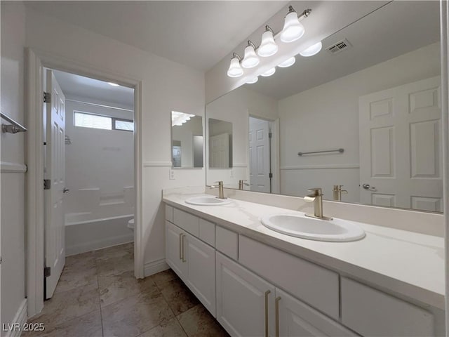 bathroom featuring double vanity, visible vents, toilet, and a sink