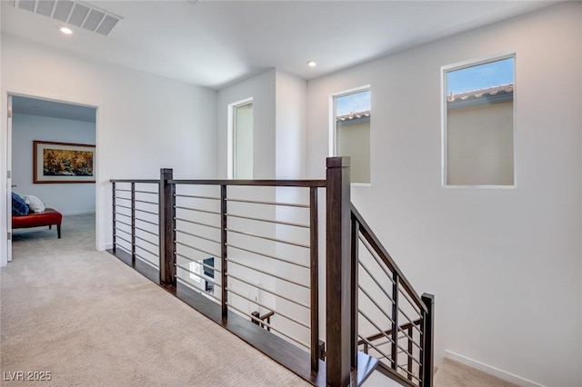 corridor featuring visible vents, baseboards, an upstairs landing, carpet floors, and recessed lighting