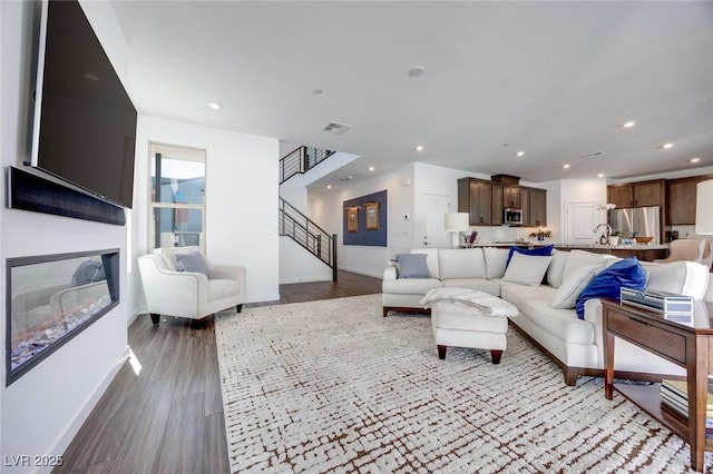 living room featuring wood finished floors, baseboards, visible vents, and recessed lighting