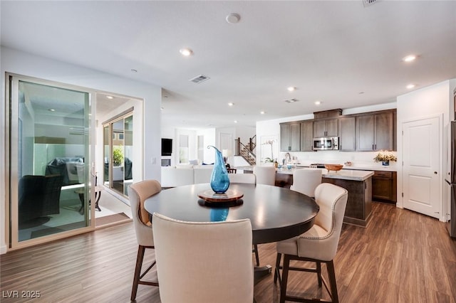 dining area with visible vents, recessed lighting, and wood finished floors