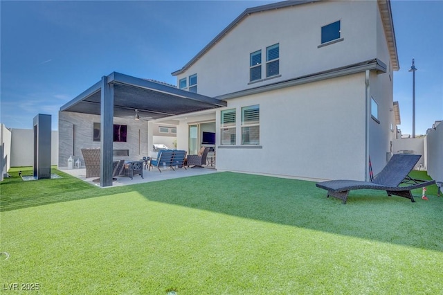 rear view of property with a yard, a patio area, stucco siding, and fence