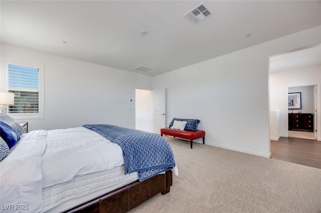 carpeted bedroom featuring baseboards and visible vents