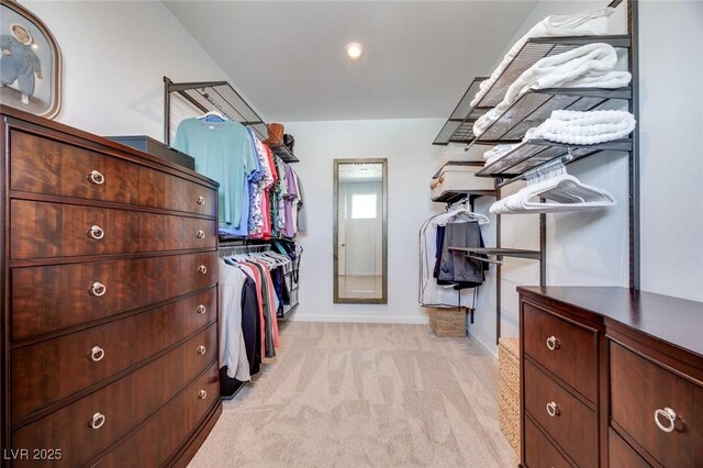 walk in closet with light colored carpet