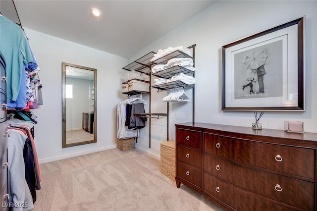 walk in closet featuring light colored carpet