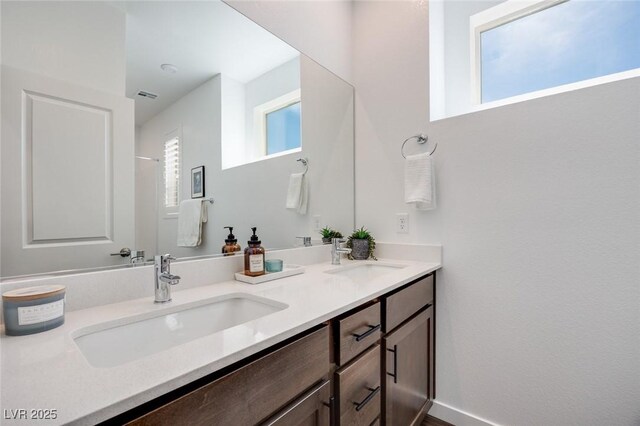 bathroom with double vanity, a sink, and visible vents