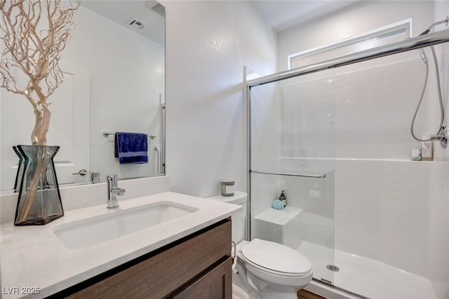 full bath featuring a shower stall, vanity, visible vents, and toilet