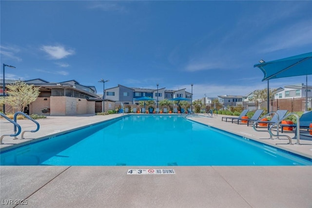 pool featuring a residential view, a patio, and fence