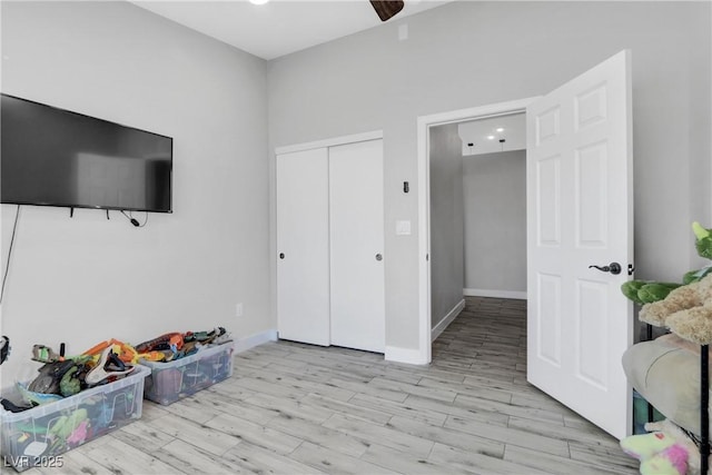 interior space with light wood-style flooring, baseboards, and a closet