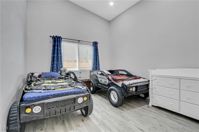 bedroom featuring lofted ceiling and wood finished floors