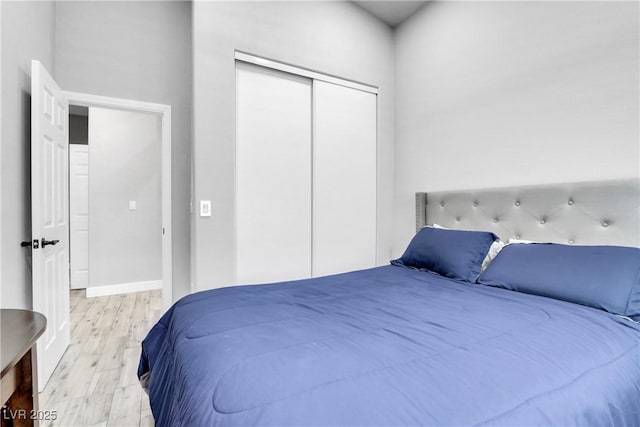 bedroom featuring wood finished floors, a closet, and baseboards