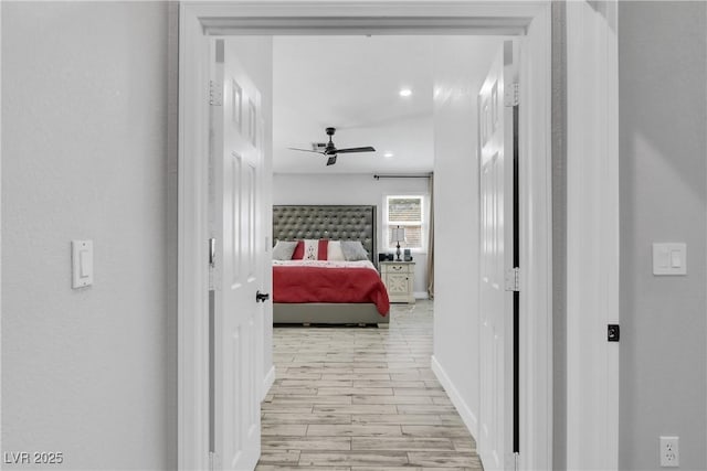 corridor with light wood finished floors and baseboards