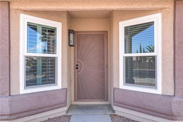 view of exterior entry with stucco siding